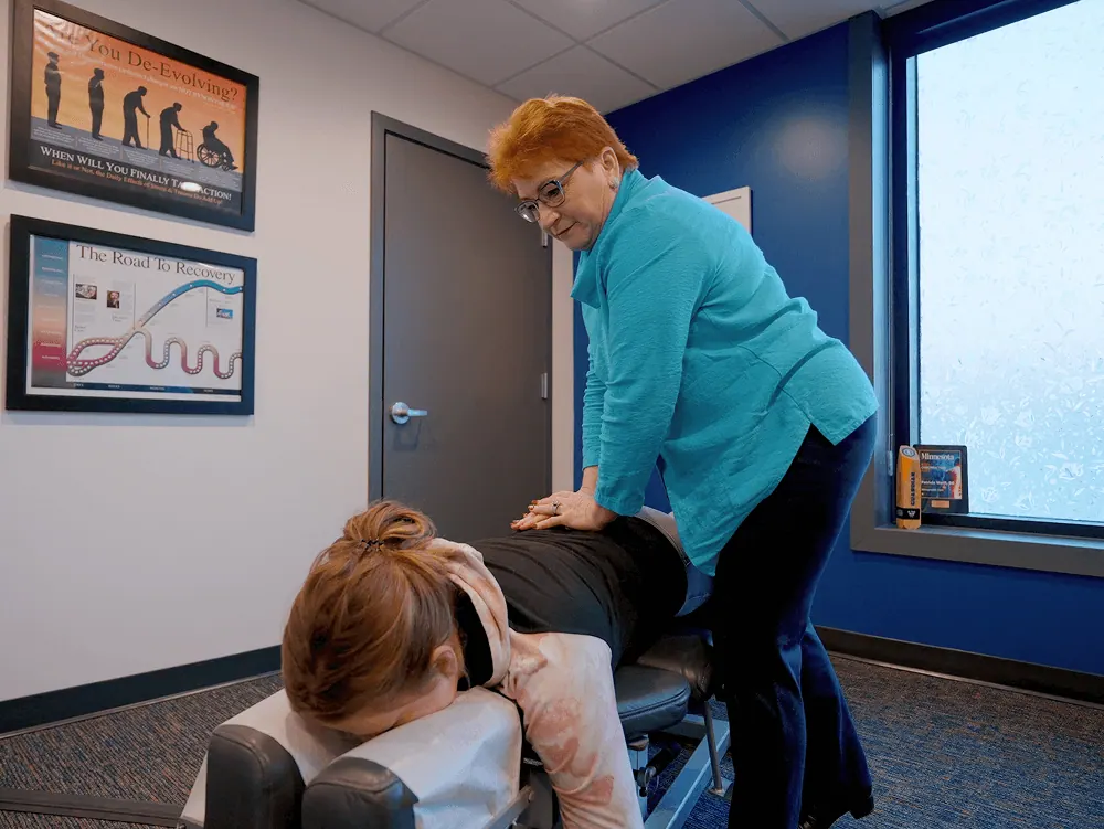 Dr. Trish Wolff adjusting a patient on the chiropractic table