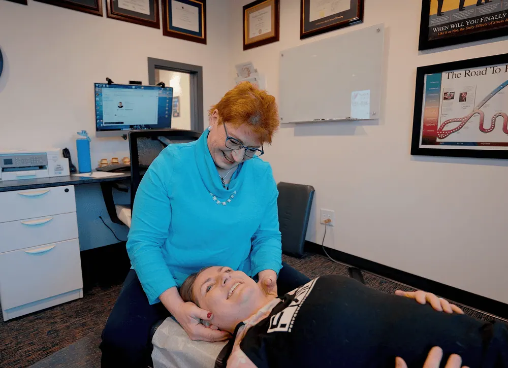 Dr. Trish Wolff treating a patient's jaw and neck