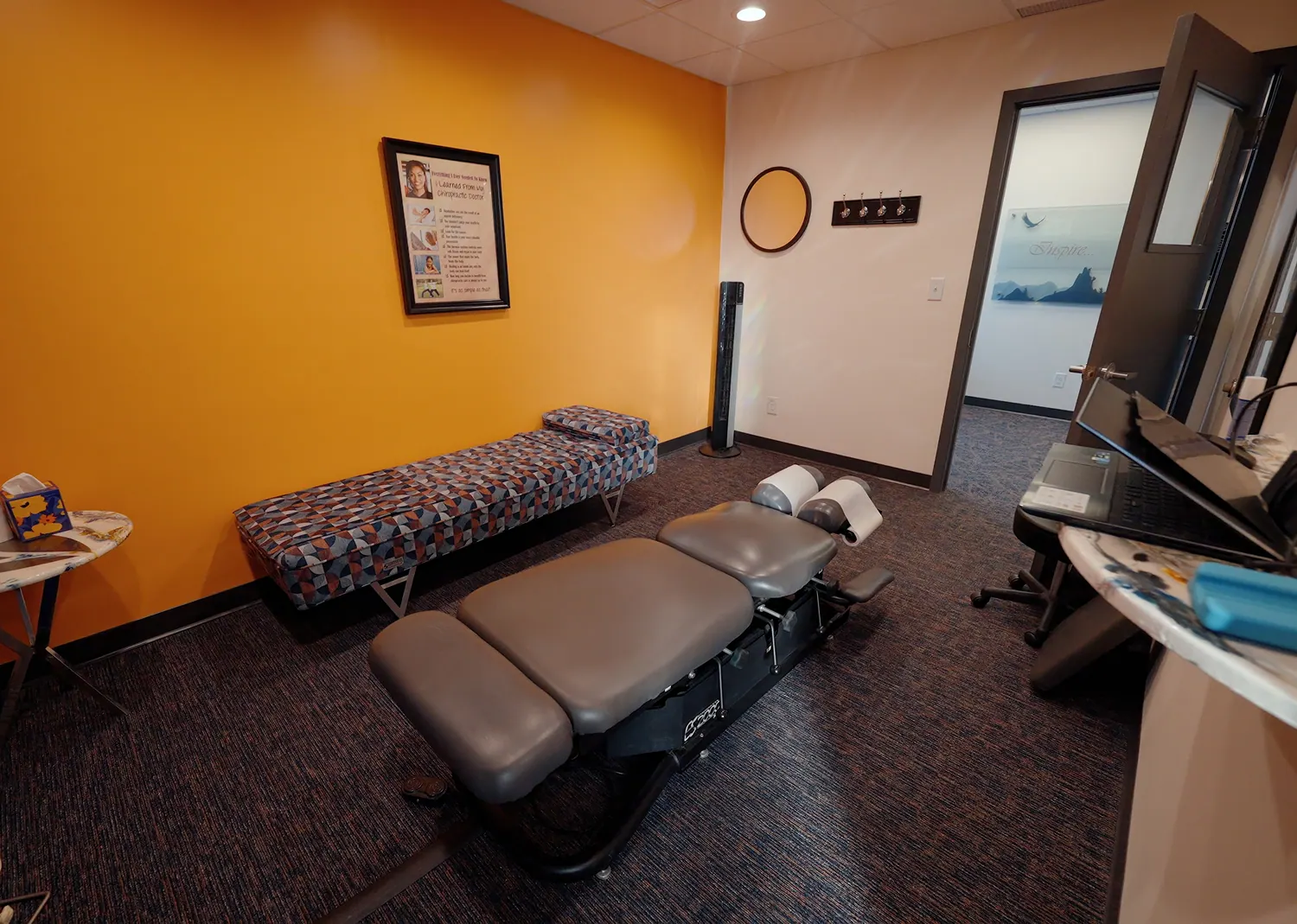 Treatment room with a massage table and patterned bench