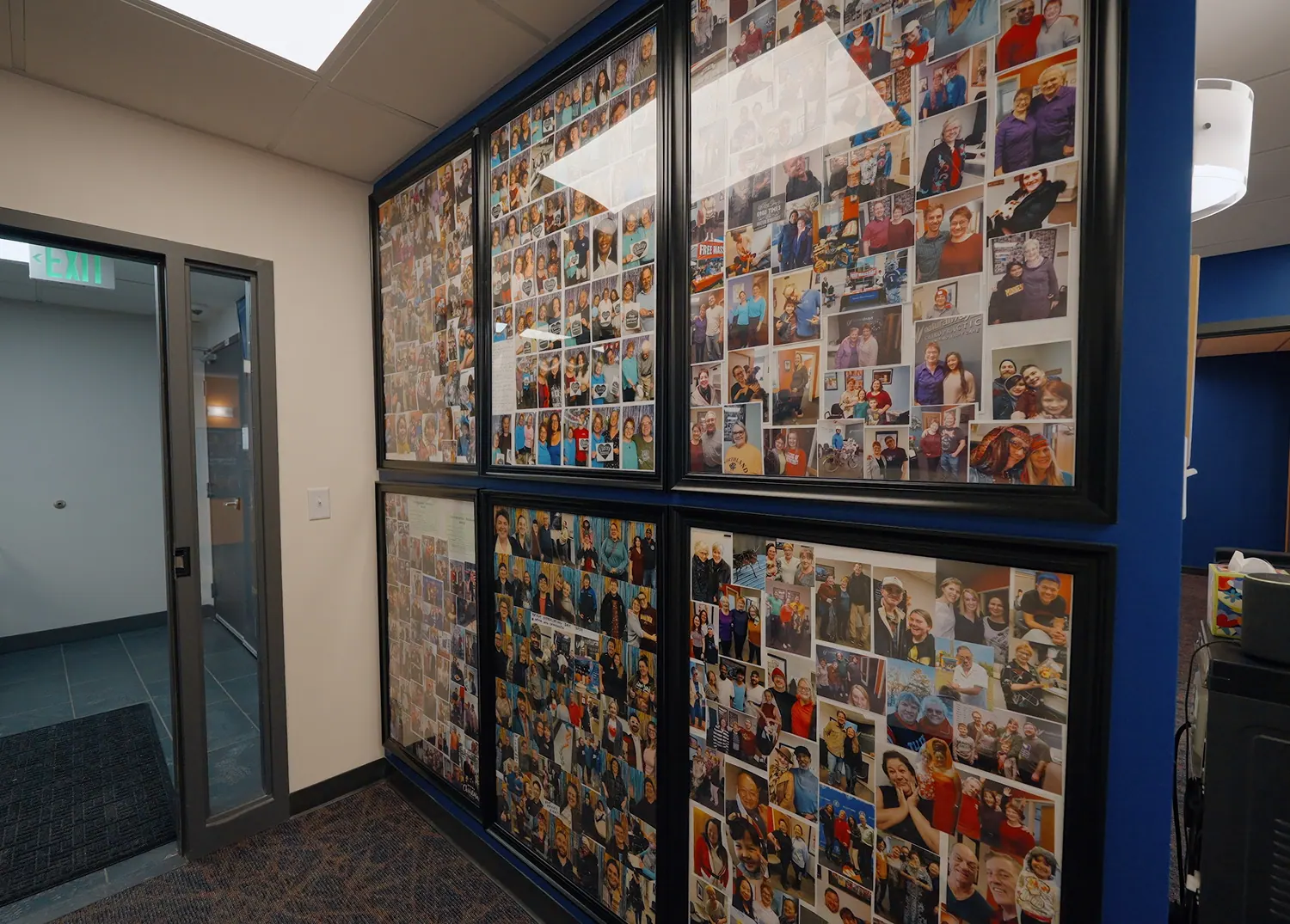 Hallway wall covered with patient photos at Natural Ways Chiropractic
