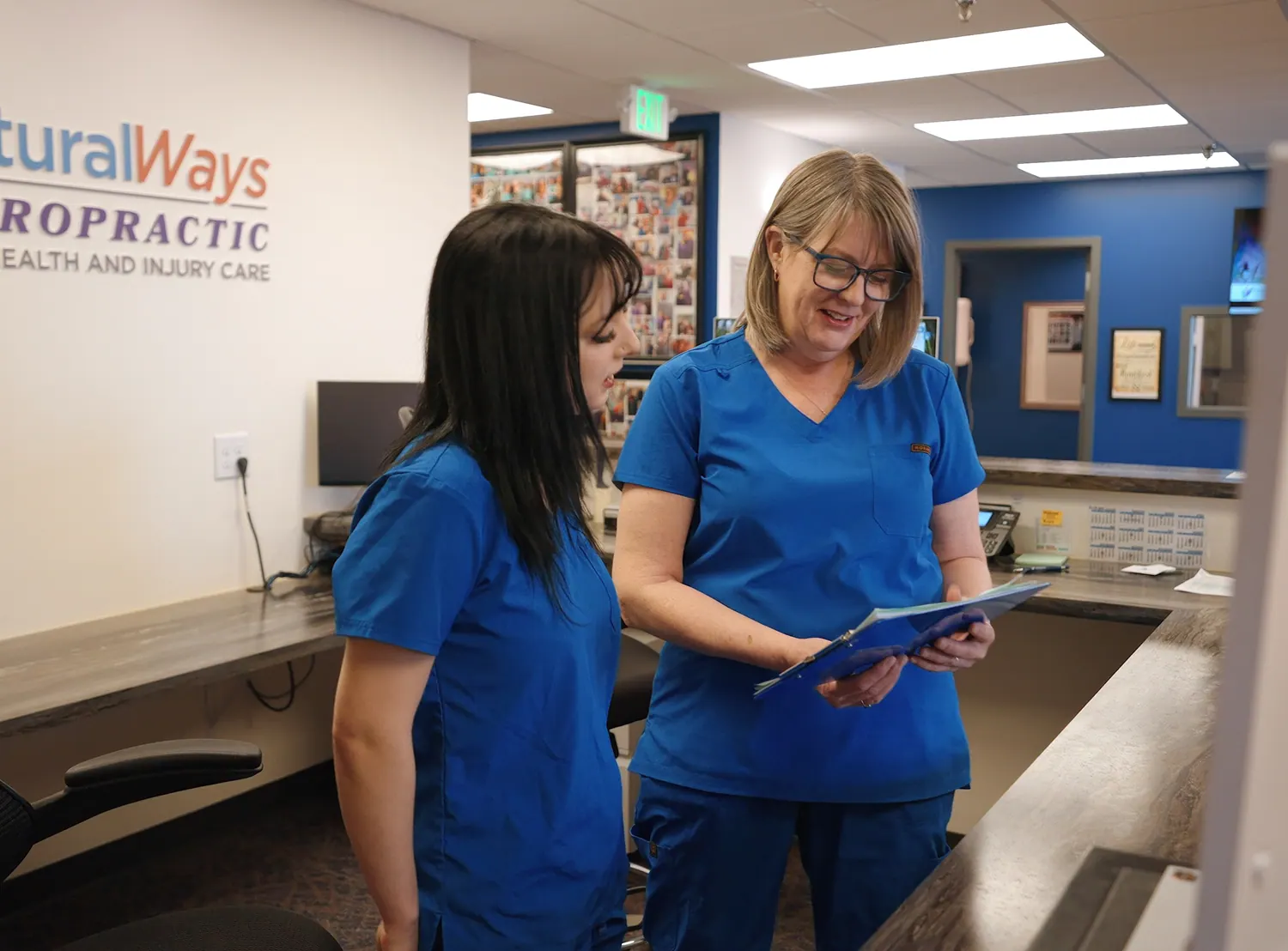 Front desk team members reviewing a patient chart at reception